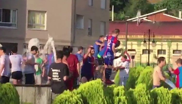 Jugadores y aficionados del Langreo festejan en la fuente su ascenso