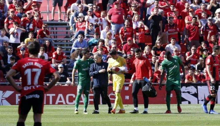 Diego Mariño sale del campo escoltado por el médico del Sporting