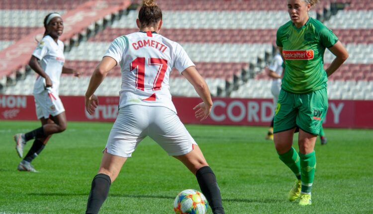 Cometti del Sevilla Fc con el balón ante una jugadora de la Real Sociedad