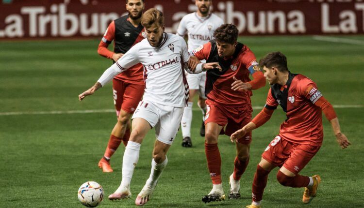 Álvaro Jiménez conduce ante jugadores del Rayo Vallecano