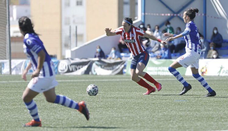 Silvia Meseguer controla el balón frente a dos jugadoras del equipo onubense